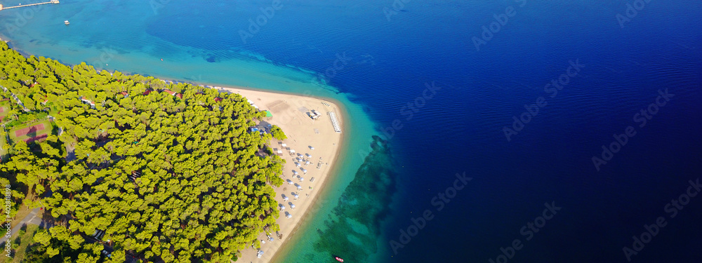 Aerial drone ultra wide panoramic photo of turquoise exotic island bay with calm sea and organised sandy beach