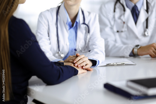 Unknown woman-doctor reassuring female patient, close-up. Two physicians consulting and giving some advices to woman. Perfect medical service, empathy imedicine during Coronavirus pandemic. Covid 2019