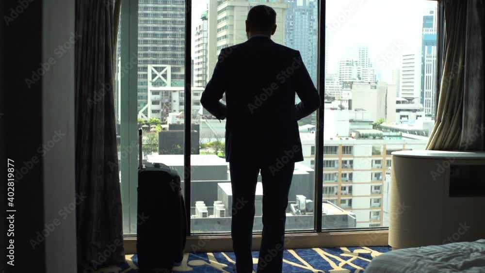 Businessman admire city view standing by window at hotel, slow motion Businessman admire city view standing by window at hotel, slow motion