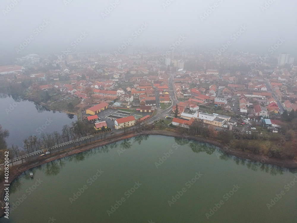 Aerial view of Dobris above pond Papez in fog