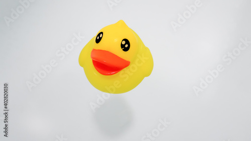 Yellow plastic duck floating on the water in the bathtub