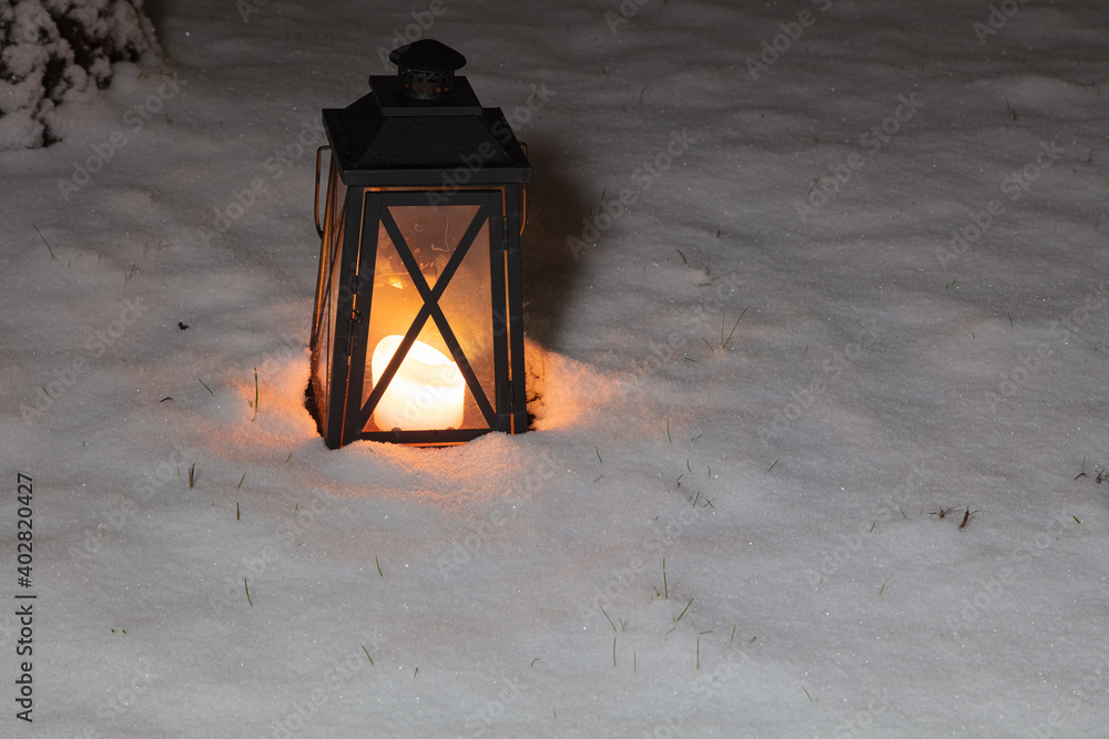 Flashlight with burning candles in the snow. Concept, winter, new year, christmas