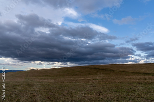 Panorama of rain clouds over a grassy meadow