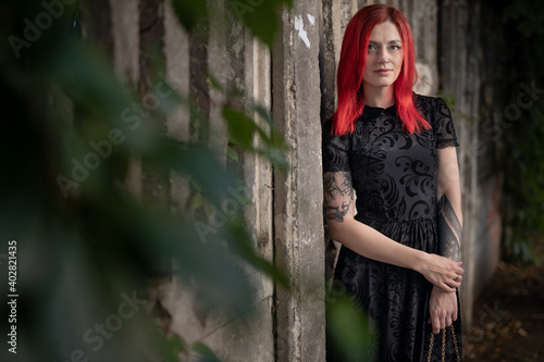 red haired girl in dress walks in park