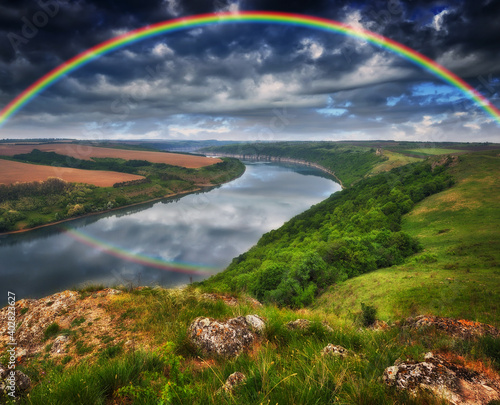 colorful rainbow over river canyon