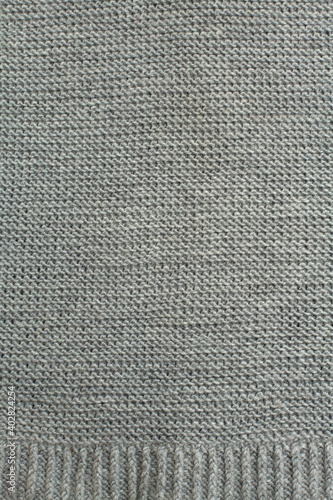 Woolen knitted fabric in gray, hand knit, garter stitch with ribs, clouseup, vertical photo