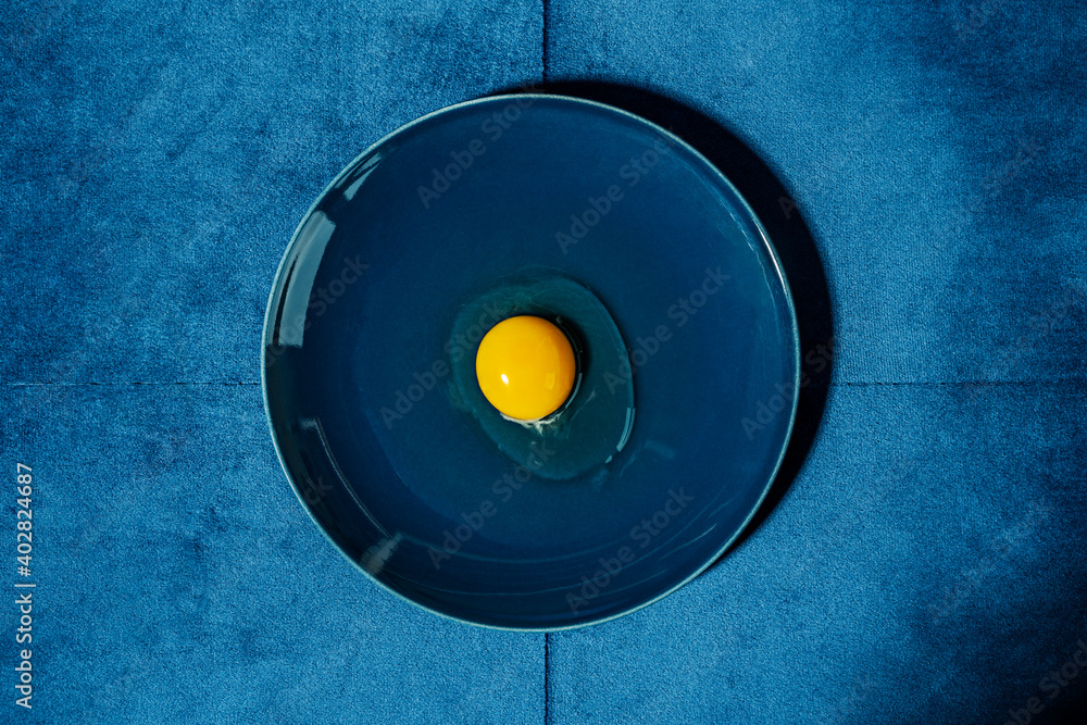 Obraz premium raw egg on blue plate