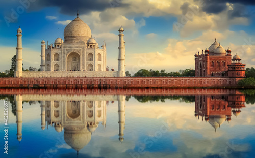 Taj Mahal with a vibrant sunset sky on the banks of river Yamuna. Taj Mahal is a white marble mausoleum designated as a UNESCO World heritage site at Agra, India. photo