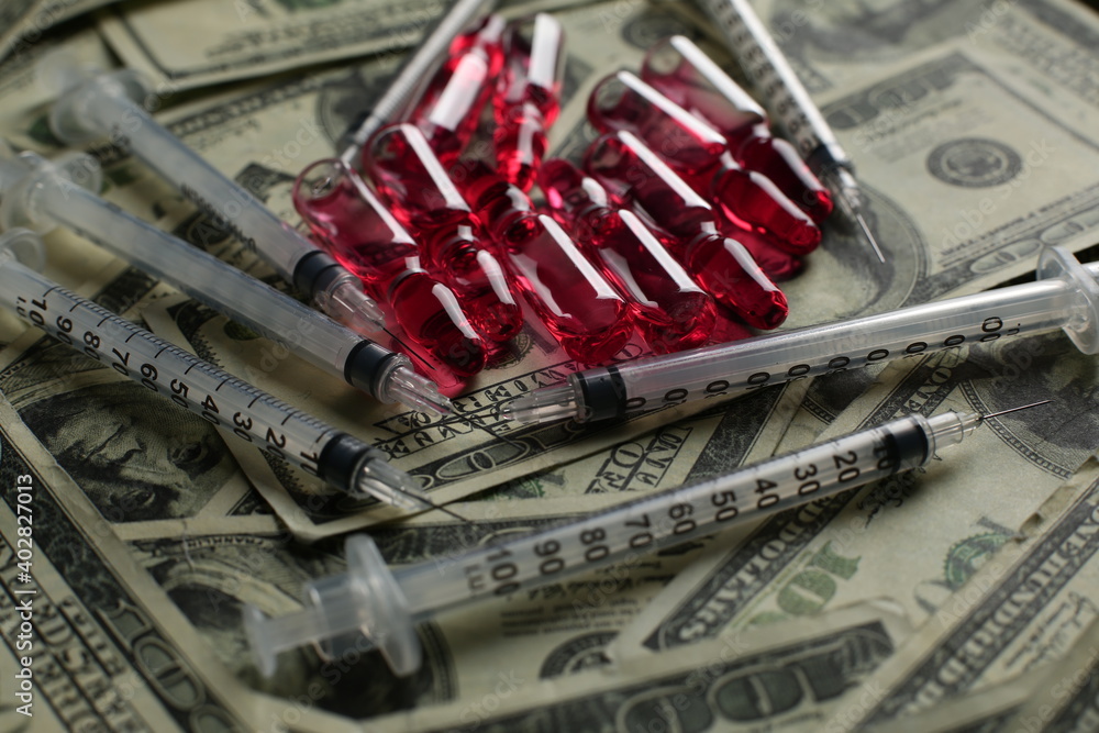 Fototapeta premium Vial with syringe vaccine and many dollars