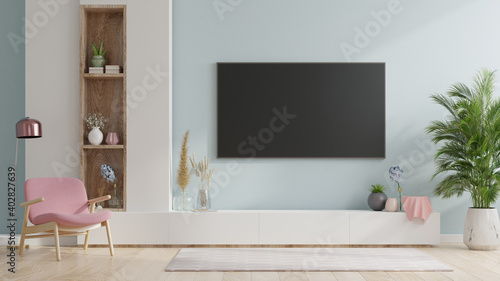 Smart TV on the blue wall in living room with armchair,minimal design.