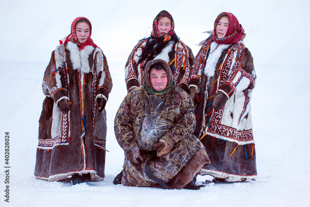 Yamalo-Nenets Autonomous Okrug, extreme north, Nenets family in the national winter clothes of the northern inhabitants of the tundra, the Arctic circle - obrazy, fototapety, plakaty 
