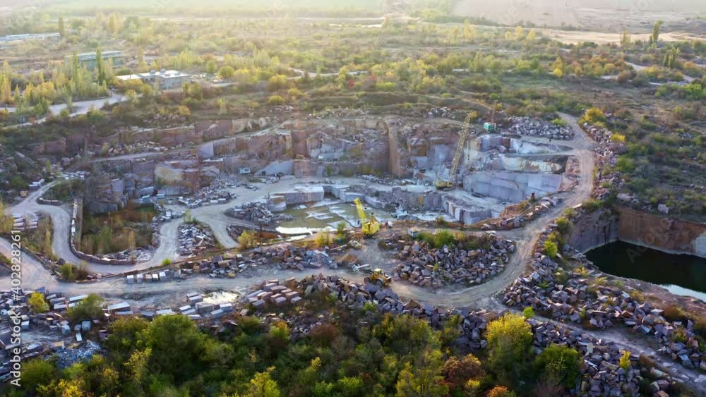 Extraction of minerals with the help of special equipment near a small lake in the warm evening light in picturesque Ukraine. Aerial UHD 4K drone realtime video, shot in 10bit HLG and colorized