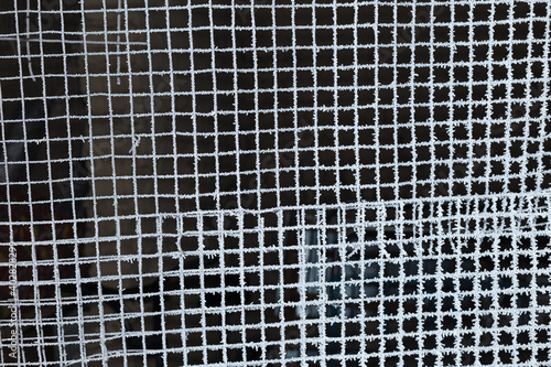 iron mesh covered with frost on a black background