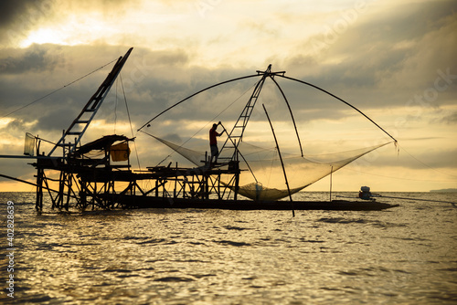 A fisherman working on giant square fishnet © Teeradej