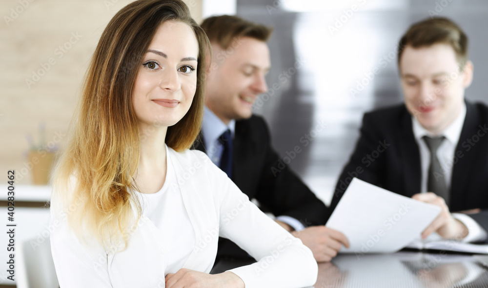 Business woman headshot at workplace in modern office. Unknown businesswoman sitting behind computer monitor. Young accountant or secretary looks good