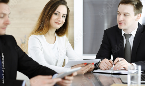 Business people or lawyers discussing questions at meeting in modern office. Unknown businessman and woman with colleague sitting and working at the glass desk. Teamwork and partnership concept