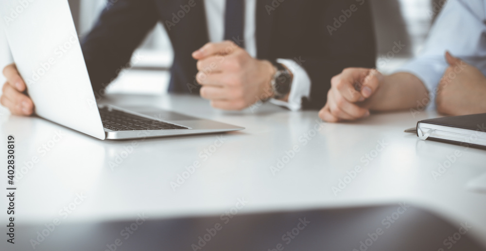 Unknown business people using laptop computer at the desk in modern office. Businessman or male entrepreneur is working with his colleague. Teamwork and partnership concept Unknown business people using laptop computer at the desk in modern office. Businessman or male entrepreneur is working with his colleague. Teamwork and partnership concept