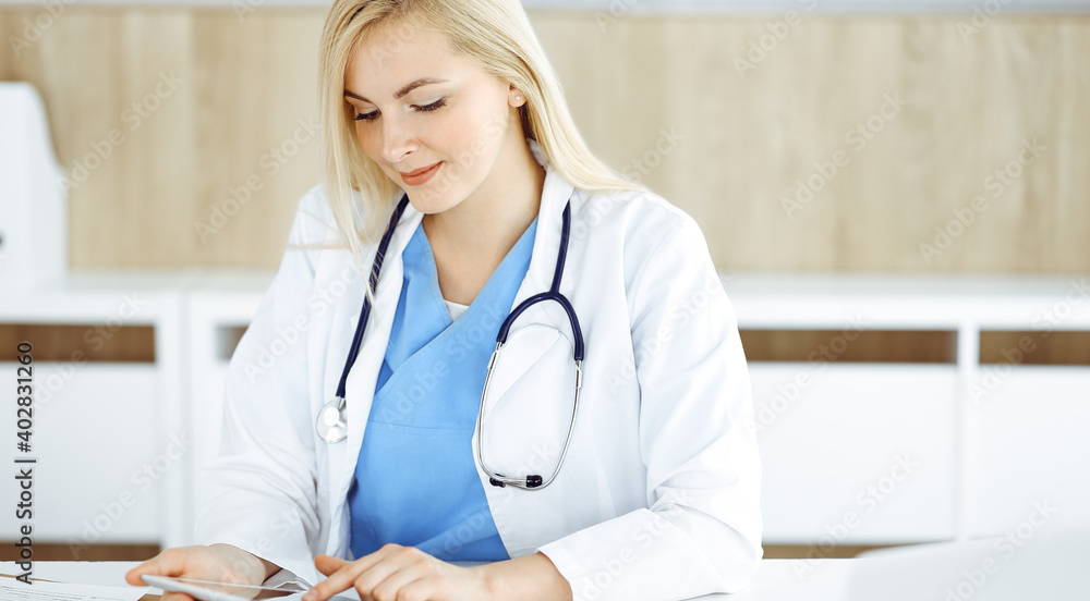 Woman-doctor standing in hospital or clinic and using tablet pc. Data and best service in medicine and healthcare Woman-doctor standing in hospital or clinic and using tablet pc. Data and best service in medicine and healthcare