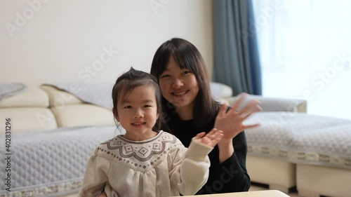 mother and daughter waving hands 