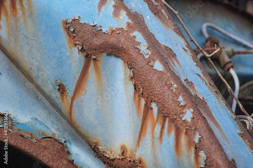 Blue paintwork and rust on a neglacted car in a scrap yard photo