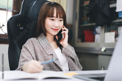 Young adult asian woman working at home office social distance from corona virus pandemic.