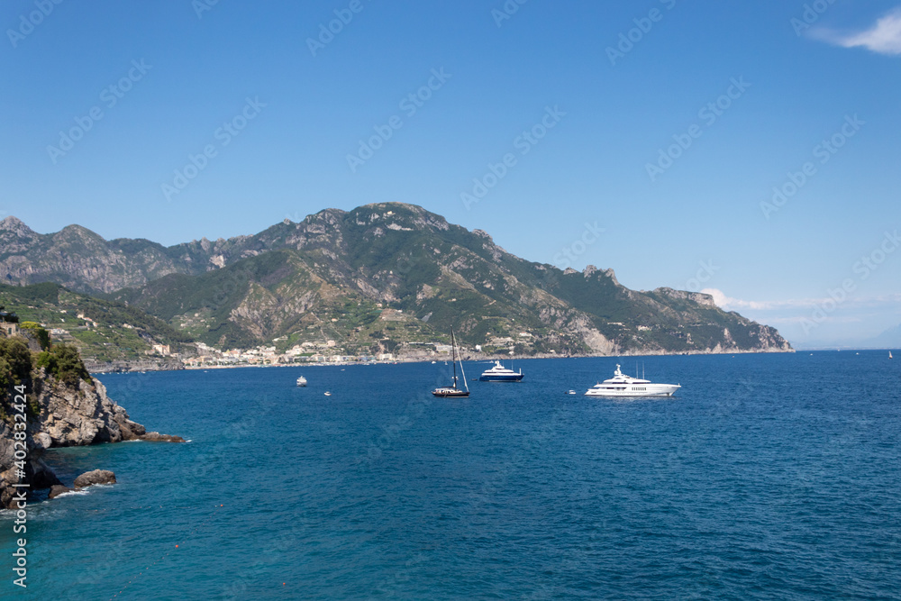 Rocky coastline on Amalfi. Sea surface with rocks and a boat.