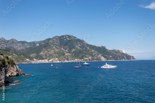 Rocky coastline on Amalfi. Sea surface with rocks and a boat.