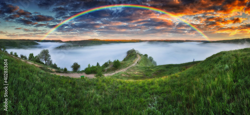 Beautiful landscape with a rainbow in the sky © sergnester