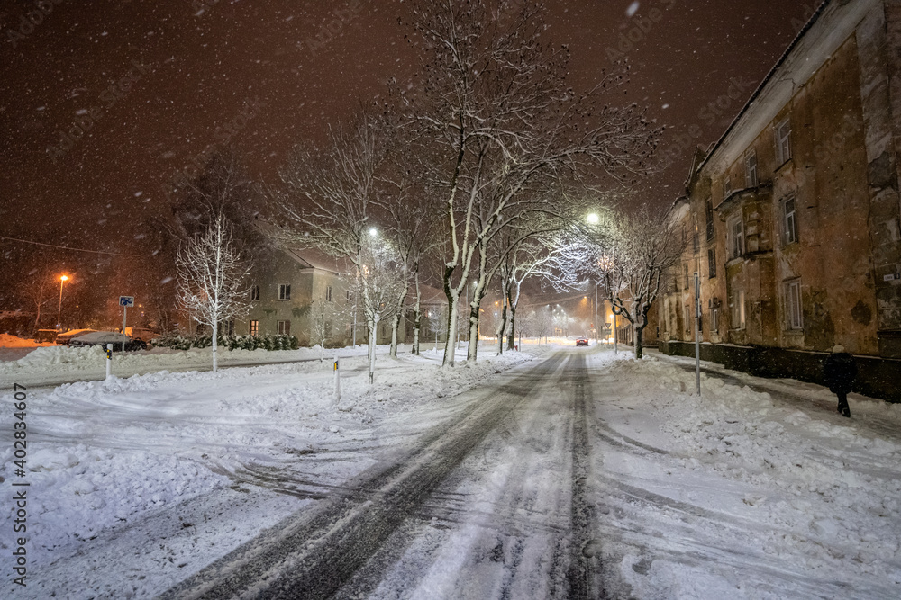 Cold winter night. Winter urban landscape. Snowfall.
