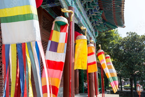 Clolorful Manchu banner and flags standing in front of ancient Chinese buildings, New Yuanming Palace, Zhuhai, China.