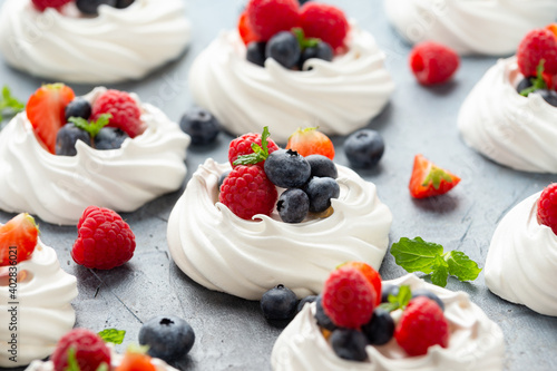 Meringue nest mini pavlova cake with fresh berries strawberry blueberry raspberry and mint for healthy desert. photo