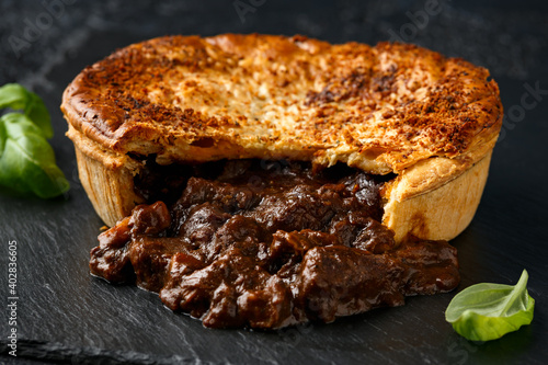 Konstfotografi British beef steak pie with onion, wine gravy on rustic stone board
