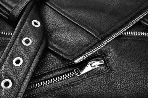 Black leather jacket close up. Textured leather, metal zipper.