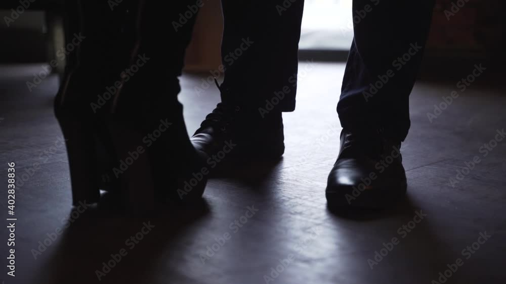 A woman in boots walks towards man in shoes. Women's and men's shoes