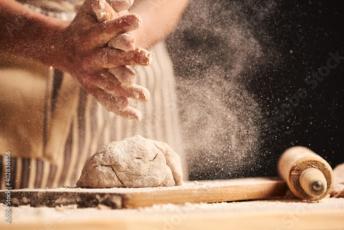 Obraz na płótnie Female baker hands making dough for bread with an apron