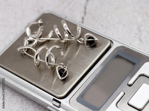 Silver earrings with hearts on electronic scales
