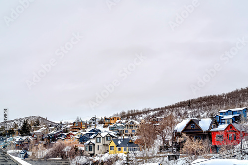 Mountain town on a cloudy winter landscape with homes on snowy slope terrain