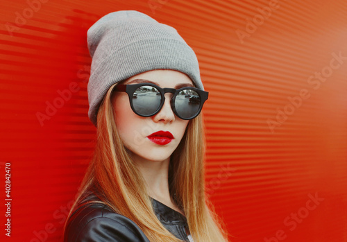 Portrait of young blonde woman in sunglasses on a red background © rohappy