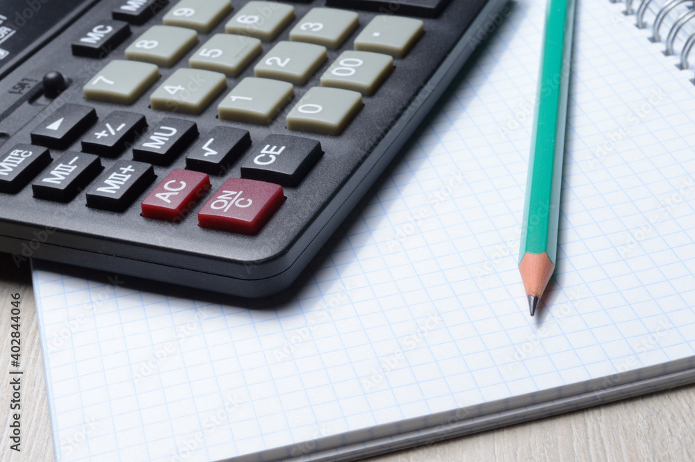 calculator, notebook and pencil lie together. close-up. calculator, notebook and pencil lie together. close-up.