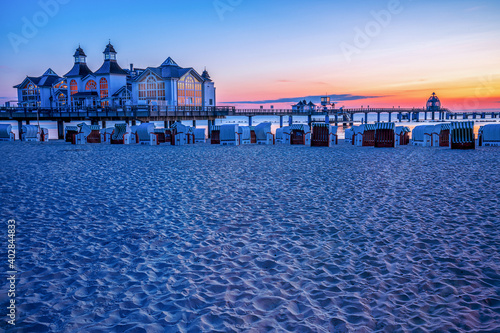 Seebrücke Sellin an der Ostsee bei Sonnenaufgang mit Strand im Vordergrund 