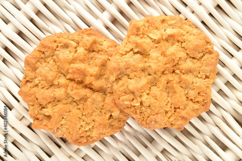 Two sweet torchetti cookies with oatmeal, close-up, on a vine mat. photo