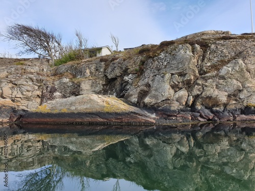 mirrored rock formation by the shore