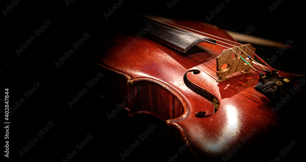Fototapeta premium Violin on a dark background. An old violin in beautiful lighting.