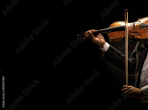 The violinist plays the violin on a dark background. photo
