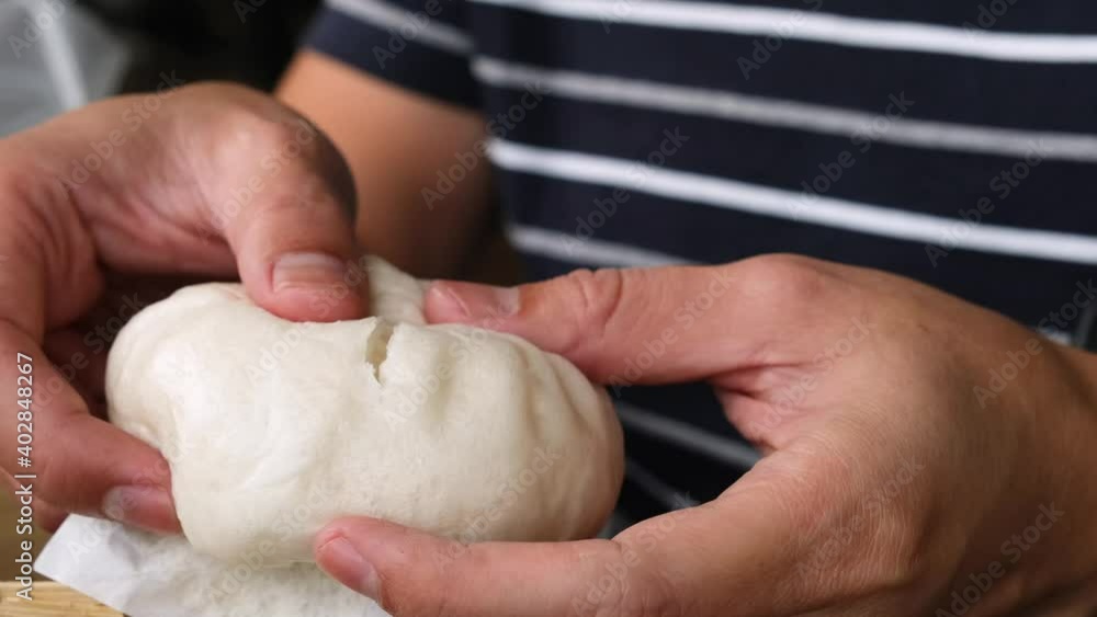 man's hand held a steamed stuff bun and revealed the gut inside man's hand held a steamed stuff bun and revealed the gut inside