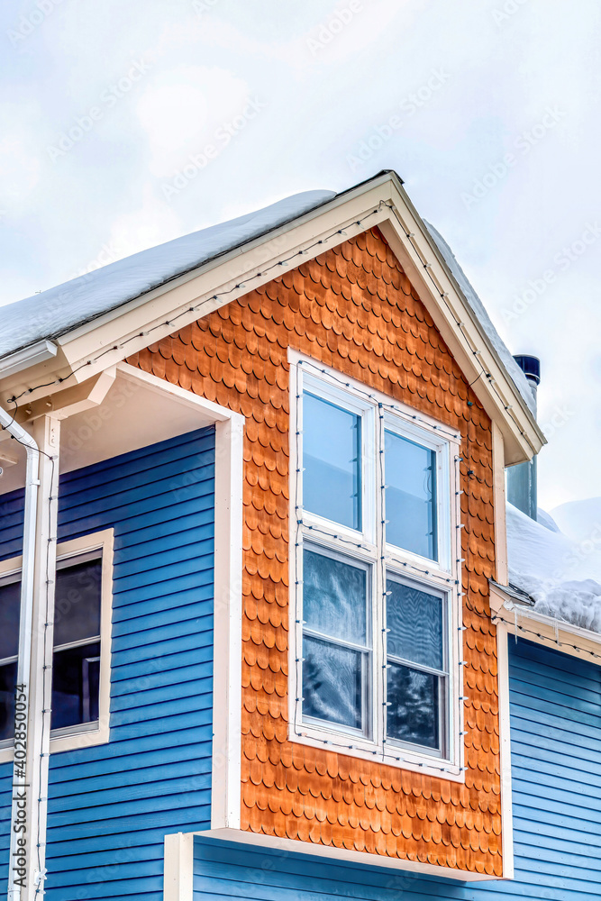 Home exterior with brown round edge shingle and blue horizontal sidings on wall Home exterior with brown round edge shingle and blue horizontal sidings on wall
