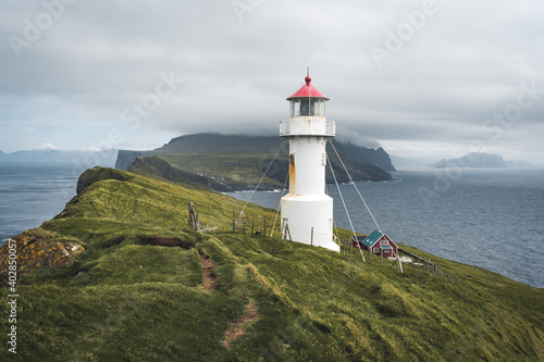 View Towards Lighthouse on the island of Mykines Holmur  Faroe Islandson a cloudy day with view towards Atlantic Ocean.