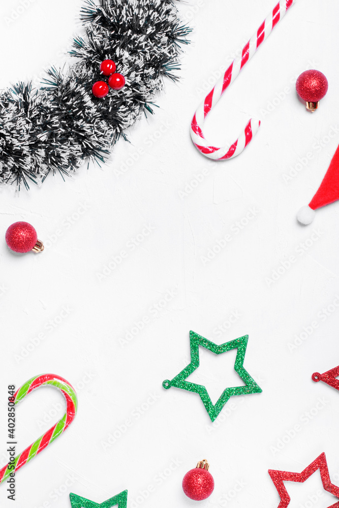 Christmas background on white with multicolored stars, candy canes, wreath and red baubles. Festive flat lay. Copy space Christmas background on white with multicolored stars, candy canes, wreath and red baubles. Festive flat lay. Copy space