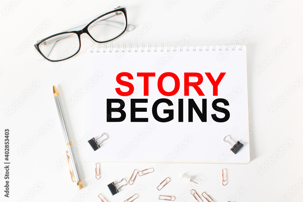 Notepad with inscriptions STORY BEGINS on a white background. business concept. Notepad with inscriptions STORY BEGINS on a white background. business concept.