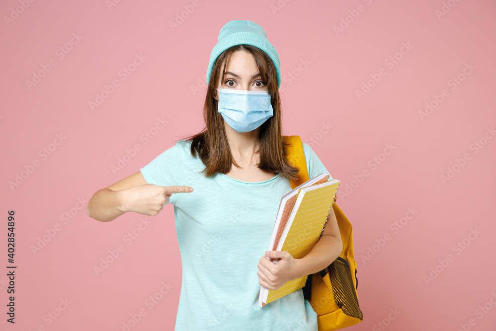 Shocked woman student in t-shirt hat backpack face mask safe from coronavirus virus covid-19 point finger on herself isolated on pink background. Education in high school university college concept. Shocked woman student in t-shirt hat backpack face mask safe from coronavirus virus covid-19 point finger on herself isolated on pink background. Education in high school university college concept.